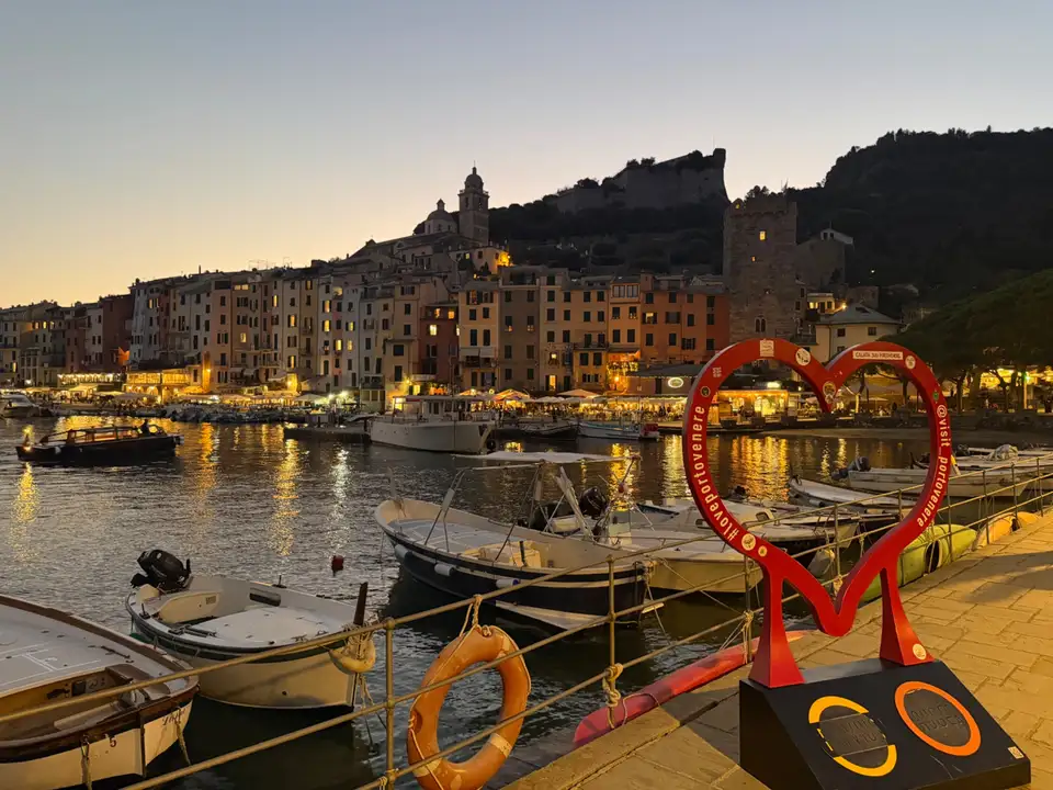 Večerní Porto Venere s barevnými domy, přístavem a hradem Doria